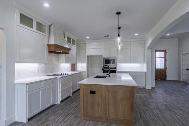 kitchen with a center island with sink, white cabinetry, sink, and built in microwave