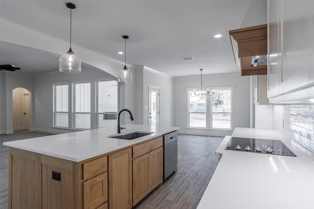 kitchen with sink, stainless steel dishwasher, an island with sink, a chandelier, and black electric cooktop