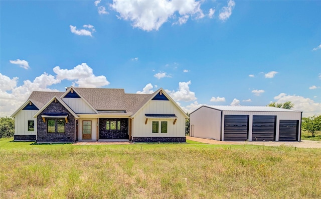 view of front facade featuring a garage, an outbuilding, and a front lawn