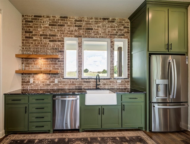 kitchen featuring sink, green cabinets, dark wood-type flooring, and appliances with stainless steel finishes