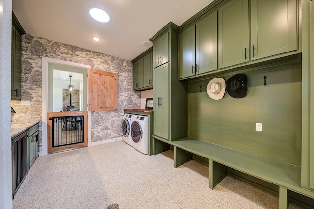 clothes washing area with washer and clothes dryer and cabinets