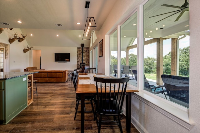 dining room with dark hardwood / wood-style flooring, ceiling fan, and a wood stove