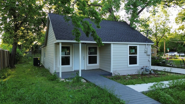 bungalow-style home featuring central AC unit and a front lawn