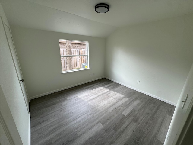 empty room featuring hardwood / wood-style flooring and vaulted ceiling