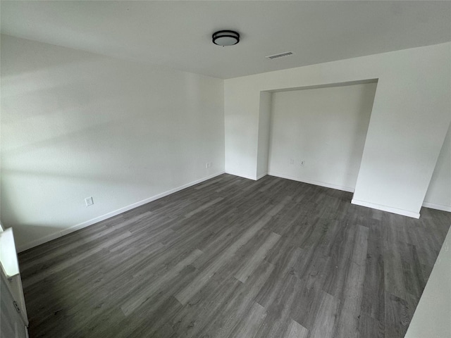 unfurnished room featuring dark wood-type flooring