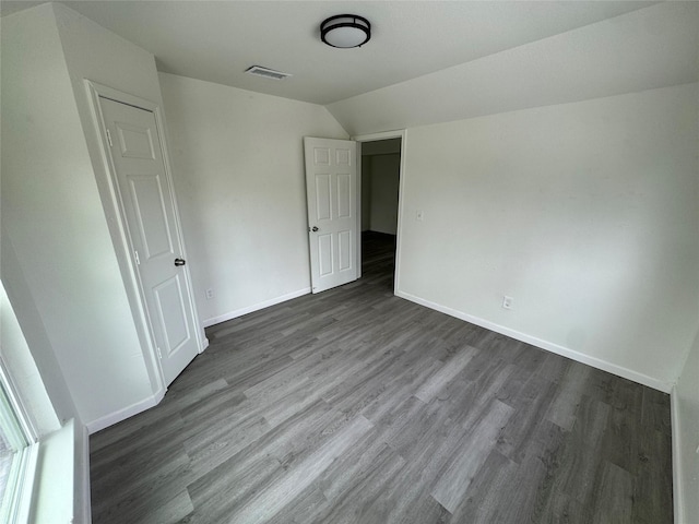 unfurnished bedroom with wood-type flooring and vaulted ceiling