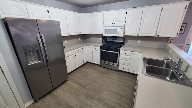 kitchen with white cabinets, dark hardwood / wood-style flooring, stainless steel appliances, and sink