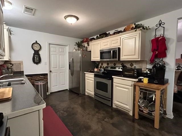 kitchen with cream cabinetry, appliances with stainless steel finishes, and sink