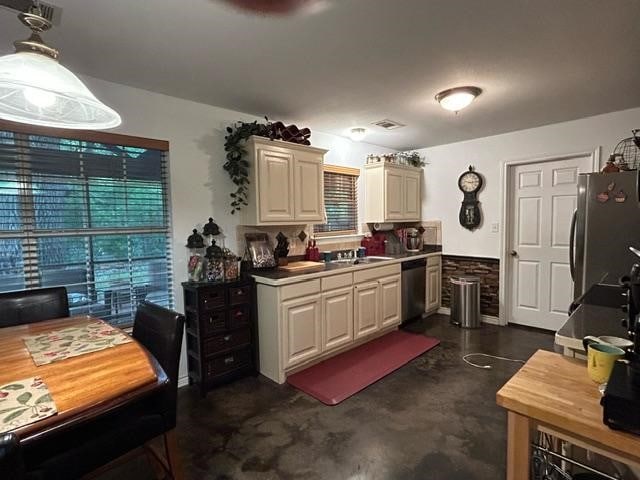 kitchen featuring appliances with stainless steel finishes, decorative light fixtures, and sink