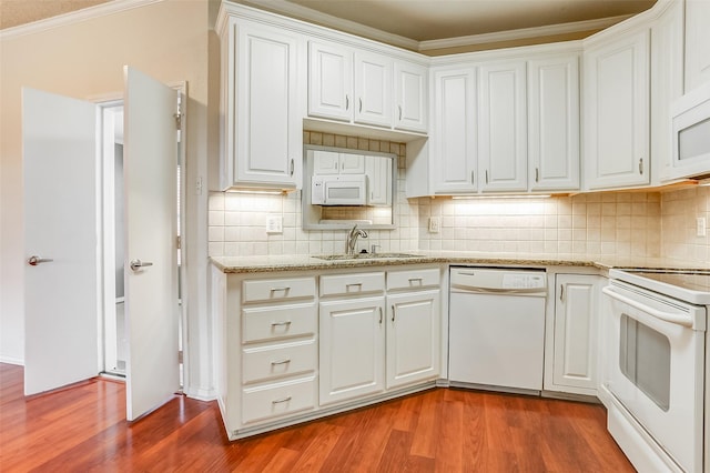 kitchen featuring hardwood / wood-style floors, white cabinetry, sink, backsplash, and white appliances