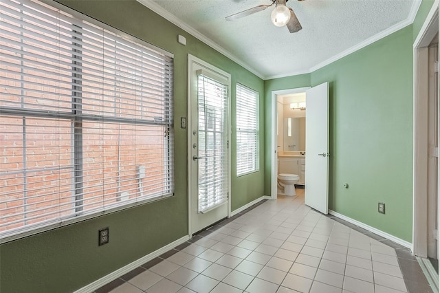 doorway with ceiling fan, light tile patterned floors, a textured ceiling, and ornamental molding