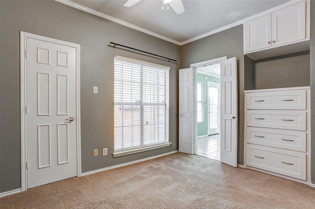 spare room featuring crown molding, light carpet, ceiling fan, and a textured ceiling