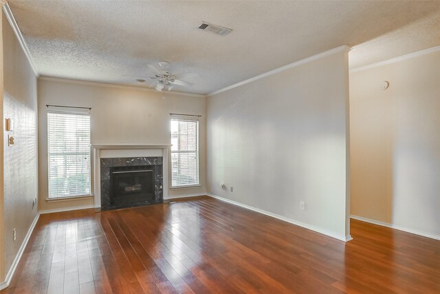 unfurnished living room with dark hardwood / wood-style floors, ceiling fan, a premium fireplace, and ornamental molding