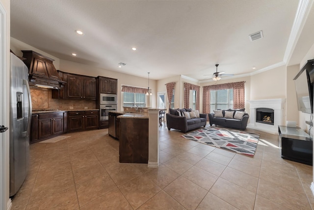 kitchen with a center island, hanging light fixtures, light tile patterned floors, dark brown cabinets, and stainless steel appliances