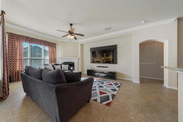 tiled living room featuring ceiling fan and crown molding