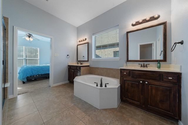 bathroom featuring tile patterned floors, ceiling fan, a washtub, and vanity