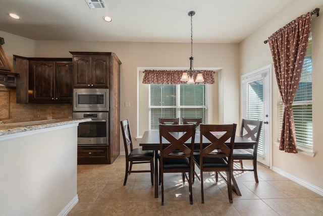 tiled dining space featuring a chandelier