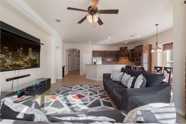 living room featuring light tile patterned floors and ceiling fan with notable chandelier