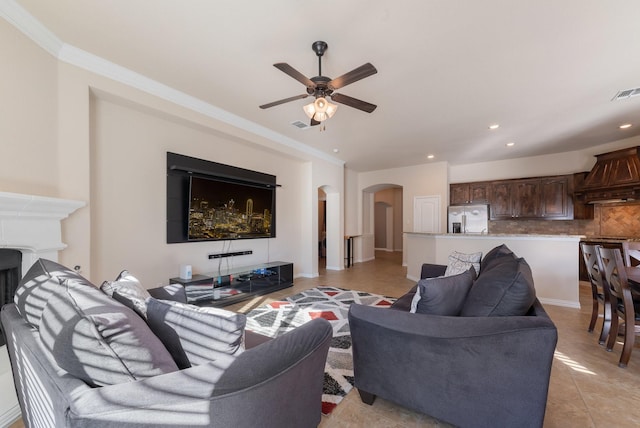 tiled living room with ceiling fan and ornamental molding