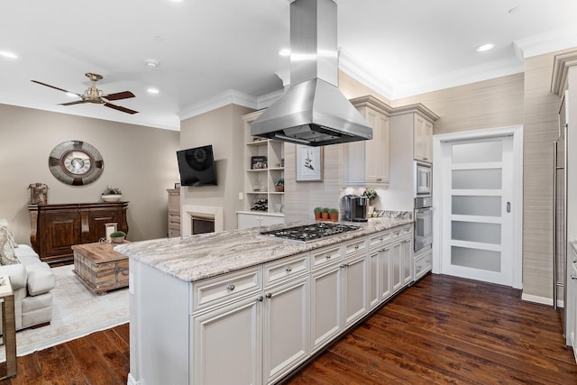 kitchen with light stone countertops, dark hardwood / wood-style flooring, island range hood, stainless steel appliances, and ceiling fan