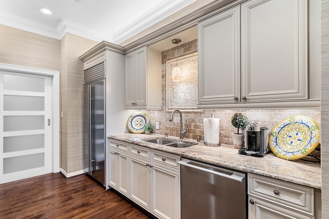 kitchen featuring light stone countertops, sink, stainless steel appliances, dark hardwood / wood-style flooring, and crown molding