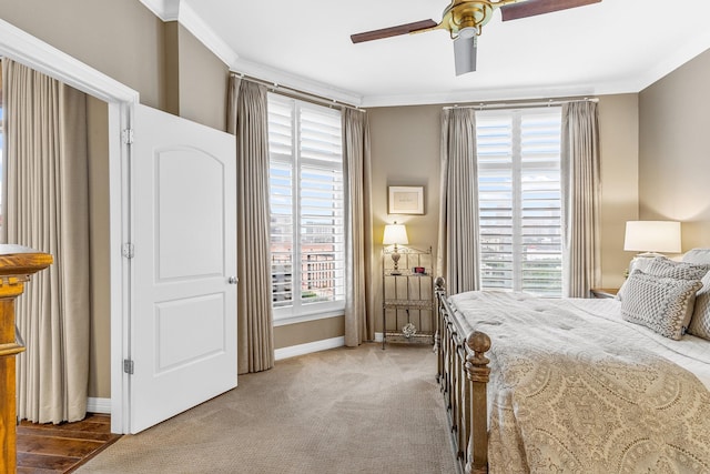 carpeted bedroom featuring ceiling fan and ornamental molding