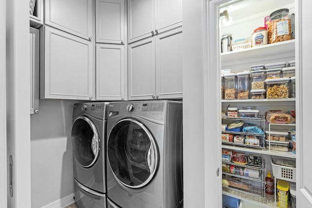 laundry room featuring cabinets and washing machine and dryer