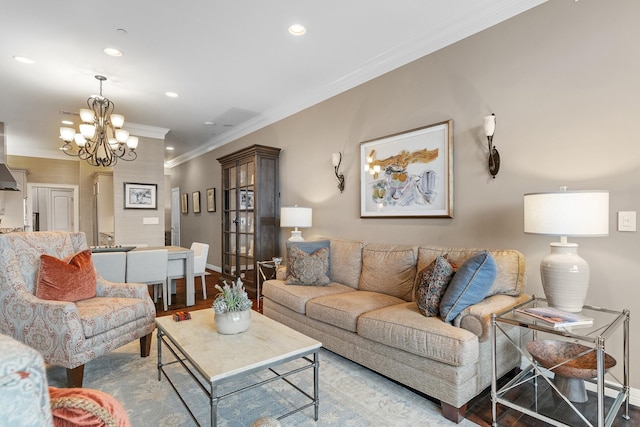 living room with a chandelier, light wood-type flooring, and ornamental molding