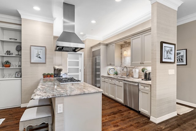 kitchen with island exhaust hood, light stone countertops, stainless steel appliances, sink, and a kitchen island