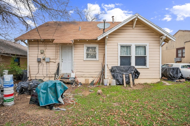 rear view of house with a lawn and cooling unit