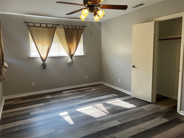 unfurnished bedroom featuring a closet, dark wood-type flooring, and ceiling fan