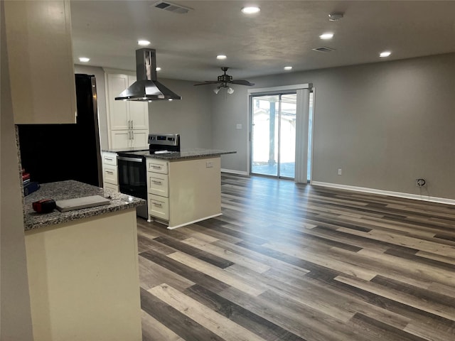 kitchen with electric range, dark stone countertops, white cabinetry, and island exhaust hood