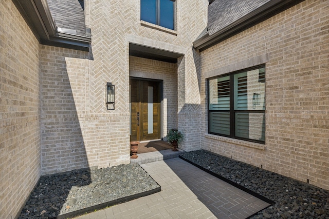 entrance to property with brick siding and a patio