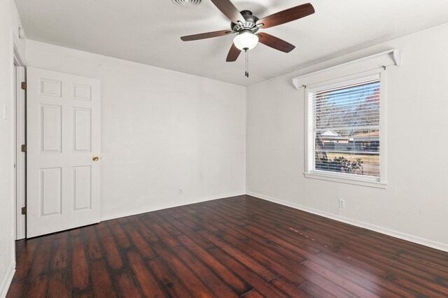 spare room with dark hardwood / wood-style flooring and ceiling fan