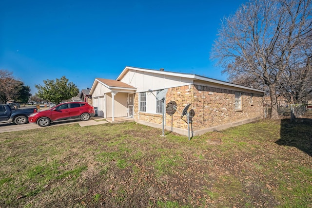 view of side of property featuring a lawn and a garage