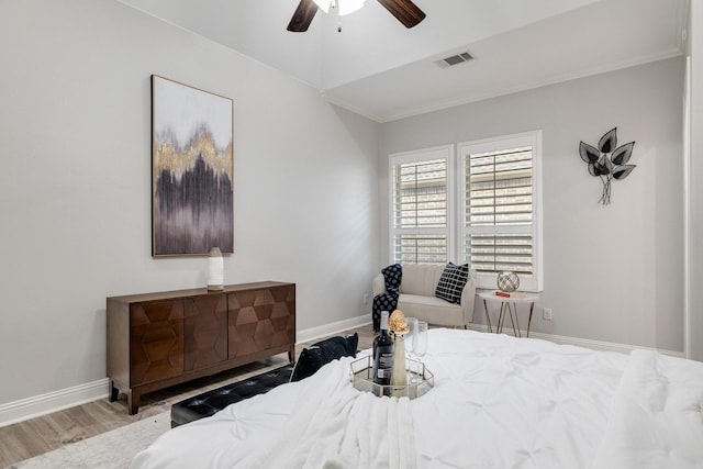 bedroom featuring ceiling fan, crown molding, and light hardwood / wood-style flooring