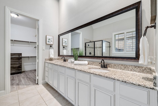 bathroom featuring tile patterned floors, vanity, and a shower with shower door