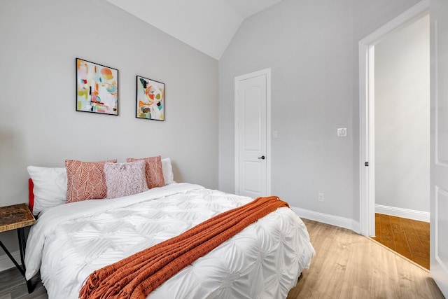 bedroom with hardwood / wood-style flooring and lofted ceiling