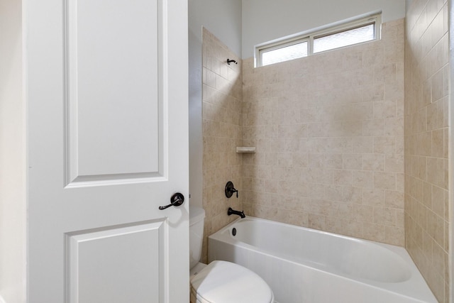 bathroom featuring toilet and tiled shower / bath