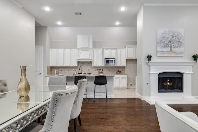 dining space featuring dark hardwood / wood-style floors, sink, and crown molding