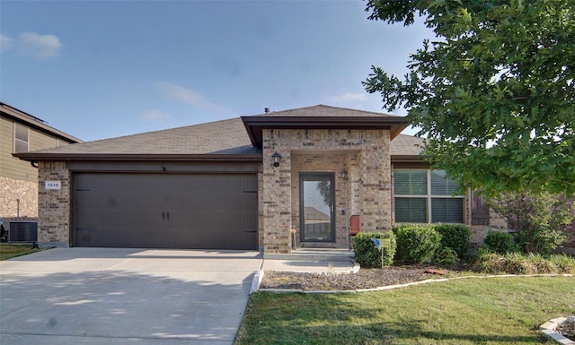 view of front of home featuring cooling unit, a garage, and a front yard