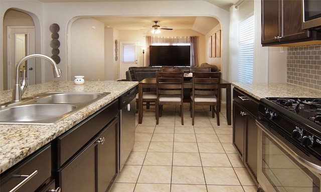 kitchen with sink, stainless steel appliances, dark brown cabinetry, light tile patterned flooring, and decorative backsplash