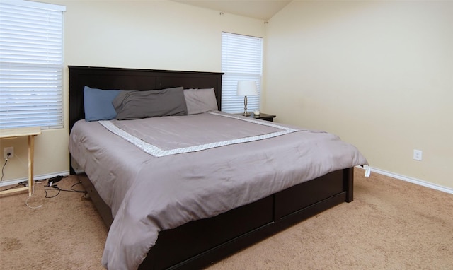 bedroom with lofted ceiling and light colored carpet