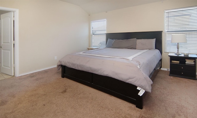 bedroom with lofted ceiling and light colored carpet