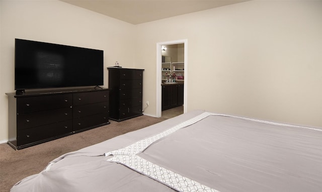 bedroom featuring ensuite bathroom and light carpet