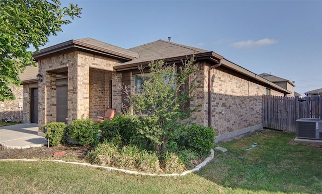 view of side of property with a garage, central air condition unit, and a yard