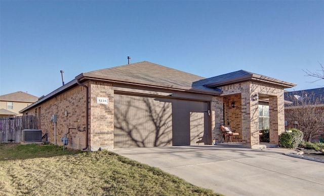 view of front of house featuring a garage, a front yard, and central AC unit