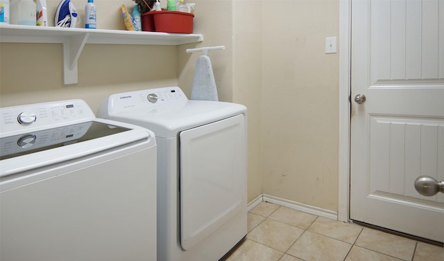 laundry area with washing machine and dryer and light tile patterned floors