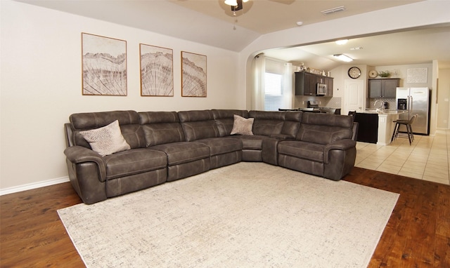 living room featuring ceiling fan, lofted ceiling, and dark hardwood / wood-style floors