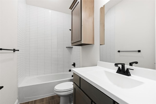 full bathroom with vanity, tiled shower / bath, hardwood / wood-style floors, and toilet